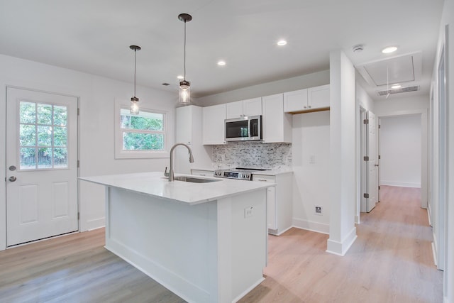 2135 Clayton St, Charleston, SC 29414 - kitchen with stainless steel appliances, a sink, white cabinetry, light wood finished floors, and tasteful backsplash