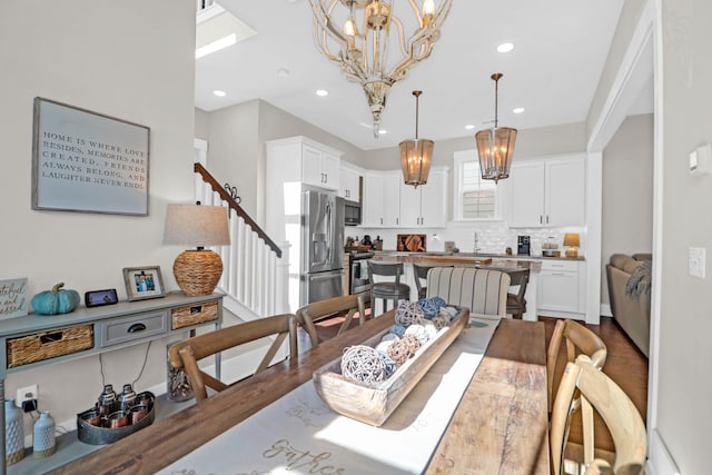 dining room featuring sink, hardwood / wood-style floors, and a notable chandelier