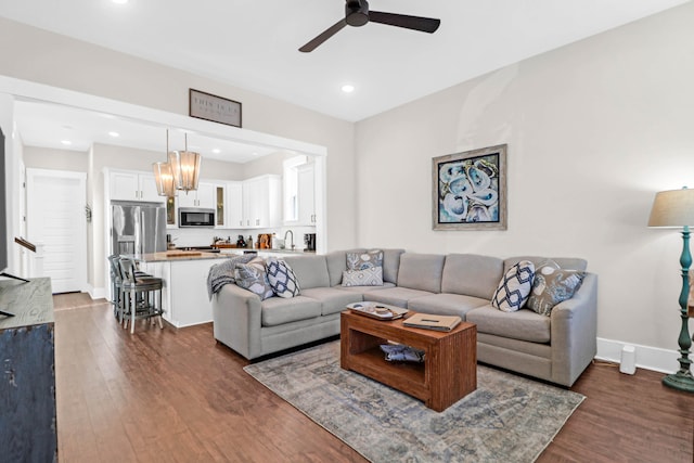 living room featuring dark hardwood / wood-style floors, sink, and ceiling fan