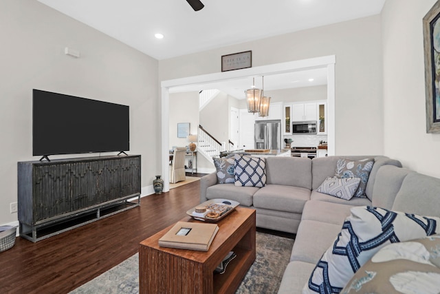 living room featuring hardwood / wood-style flooring and ceiling fan with notable chandelier