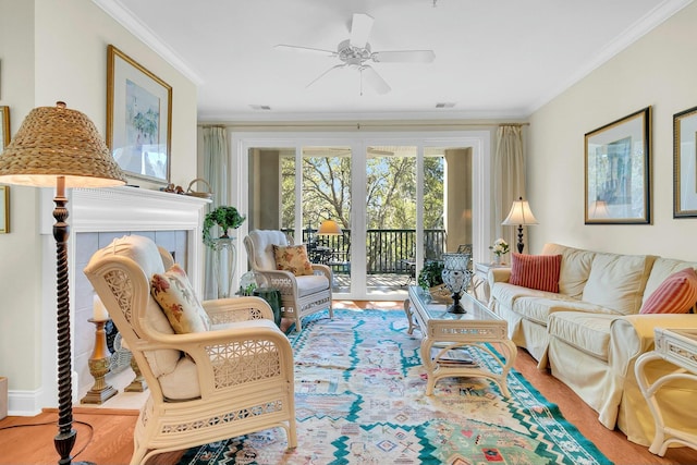 living room with ornamental molding, light hardwood / wood-style floors, and ceiling fan