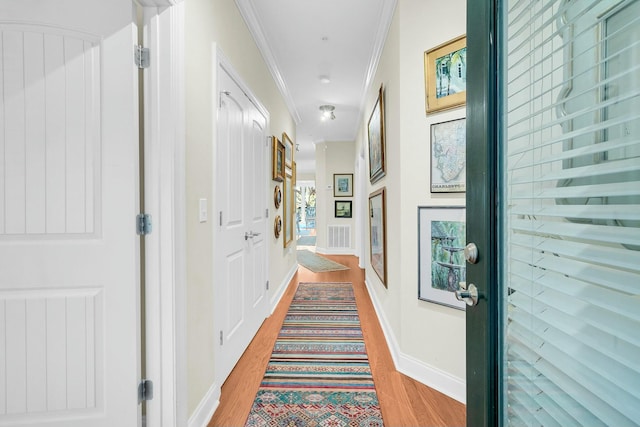 corridor featuring crown molding and light wood-type flooring