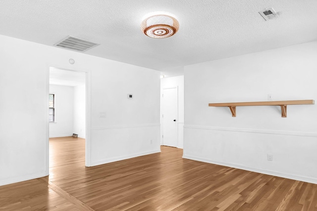 spare room with hardwood / wood-style floors and a textured ceiling