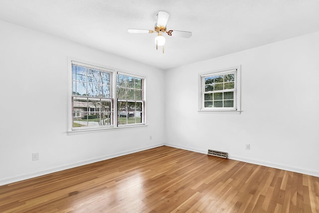 unfurnished room with hardwood / wood-style flooring, ceiling fan, and a wealth of natural light