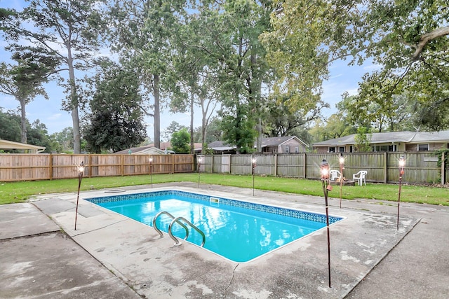 view of swimming pool featuring a patio and a yard