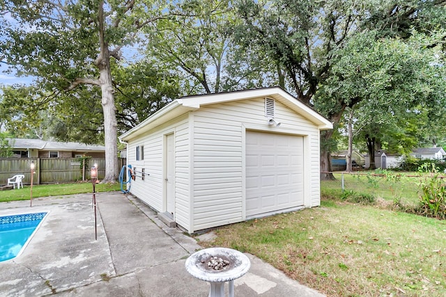 garage with a yard and a fenced in pool