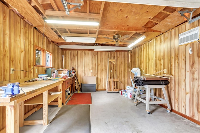 interior space featuring ceiling fan, a wall unit AC, wooden walls, and a workshop area