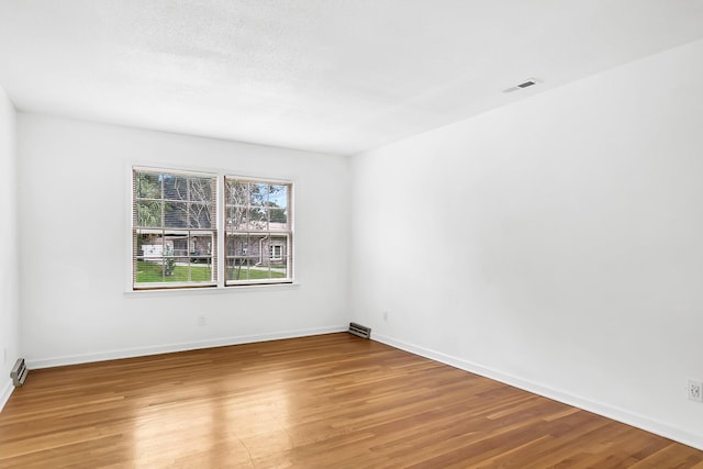 spare room featuring hardwood / wood-style floors and a textured ceiling