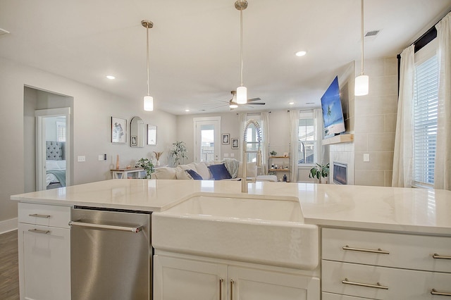 kitchen featuring hardwood / wood-style flooring, white cabinetry, hanging light fixtures, and light stone counters