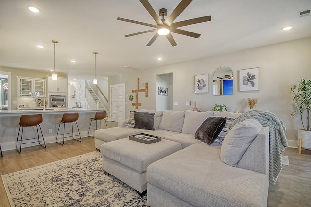 living room featuring light hardwood / wood-style flooring and ceiling fan