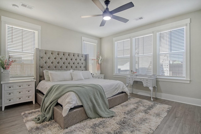 bedroom featuring multiple windows, dark hardwood / wood-style flooring, and ceiling fan