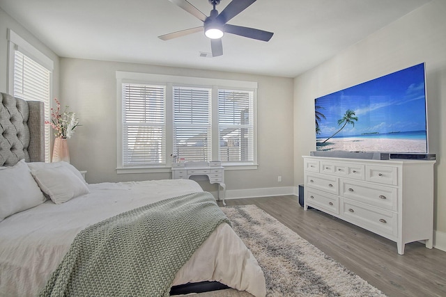 bedroom featuring multiple windows, hardwood / wood-style floors, and ceiling fan