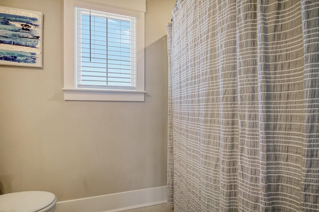 bathroom with tile patterned floors, plenty of natural light, and toilet