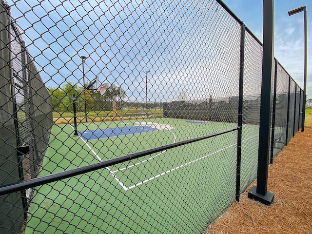 view of tennis court featuring basketball hoop