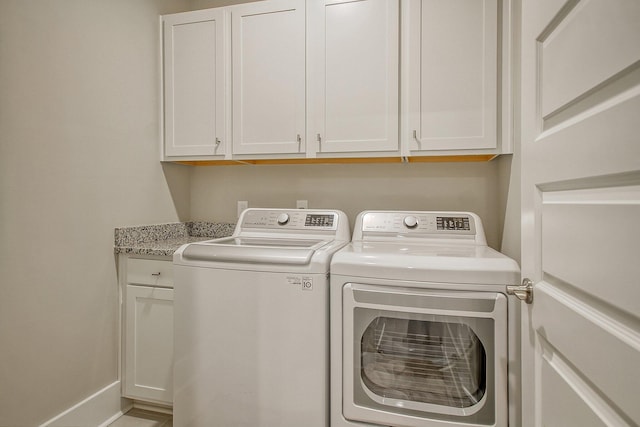 laundry area featuring cabinets and washer and clothes dryer