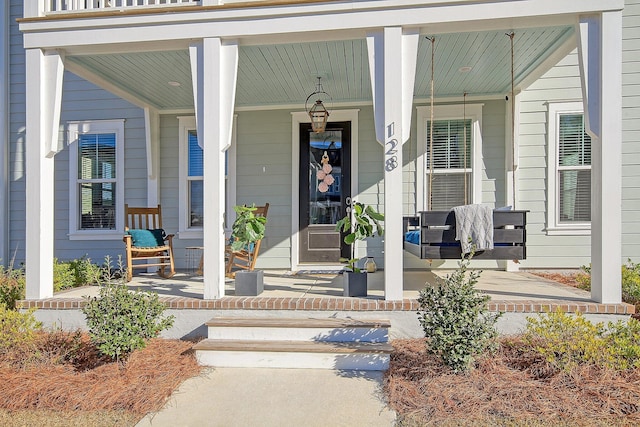 view of exterior entry featuring covered porch