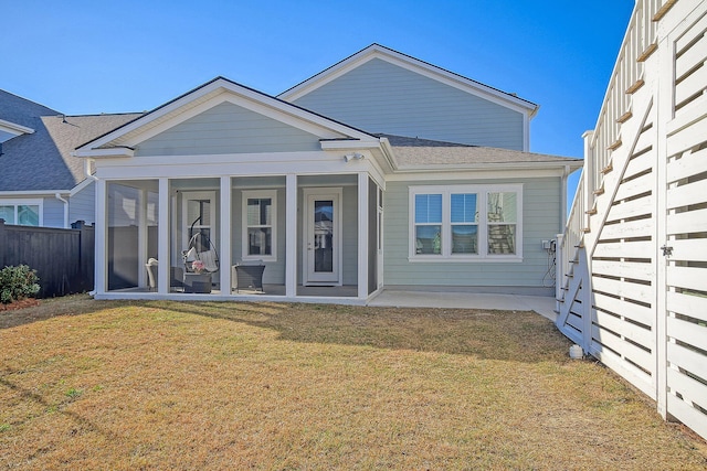 bungalow with a sunroom, a front yard, and a patio area