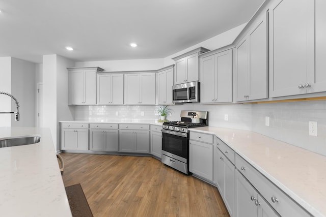 211 Squire Pope Rd, Summerville, SC 29486 - kitchen featuring stainless steel appliances, a sink, gray cabinetry, light wood finished floors, and recessed lighting