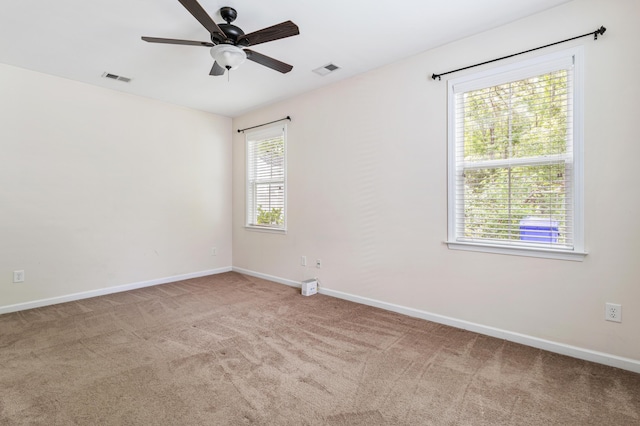 empty room featuring light colored carpet and ceiling fan