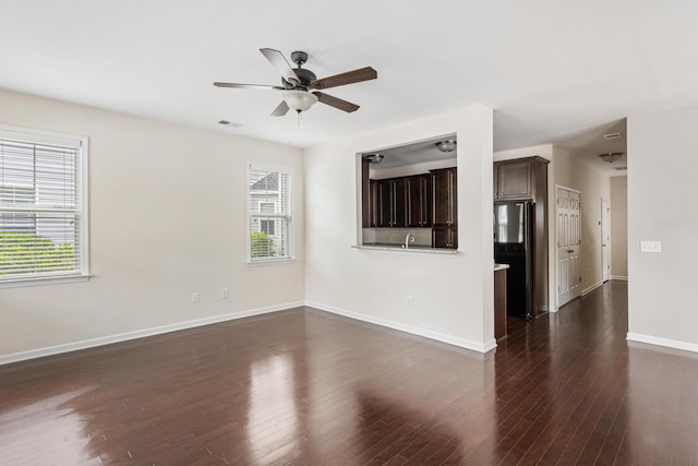 unfurnished living room featuring dark wood-type flooring, ceiling fan, and sink