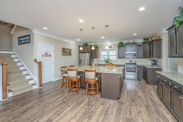 220 Brutus Ln, Summerville, SC 29485 - kitchen with stainless steel appliances, ornamental molding, a sink, an island with sink, and light stone countertops