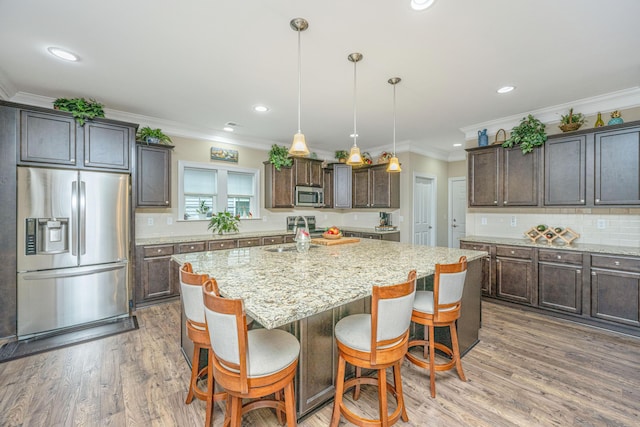 220 Brutus Ln, Summerville, SC 29485 - kitchen with stainless steel appliances, crown molding, an island with sink, dark brown cabinetry, and tasteful backsplash
