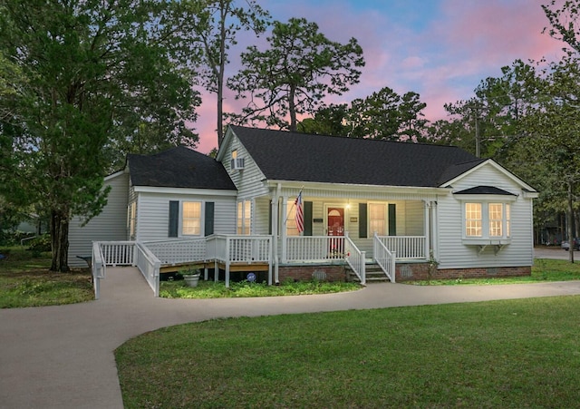 view of front of property with a porch and a lawn