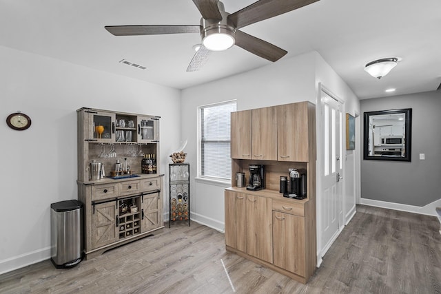 kitchen featuring hardwood / wood-style flooring, ceiling fan, sink, and decorative backsplash