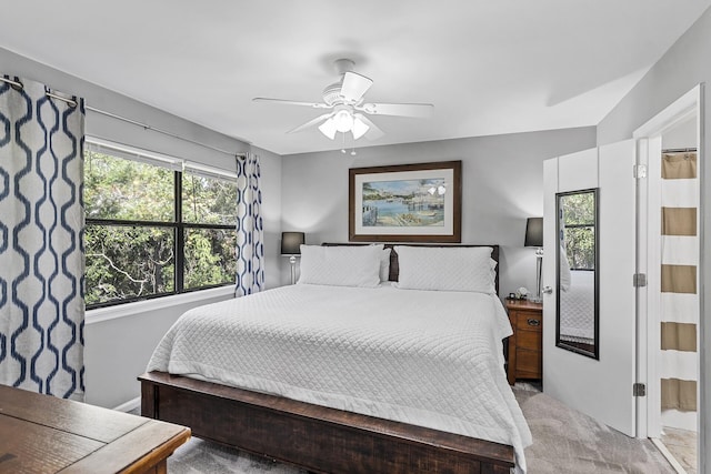 bedroom with light carpet, connected bathroom, and ceiling fan