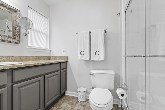 bathroom with vanity, a shower with shower door, and toilet