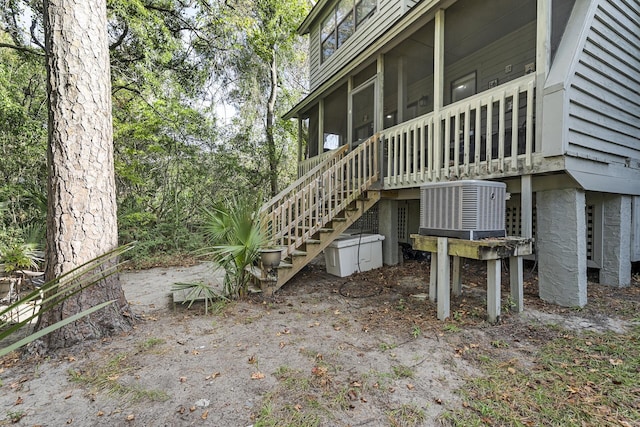 view of property exterior featuring central AC and a sunroom