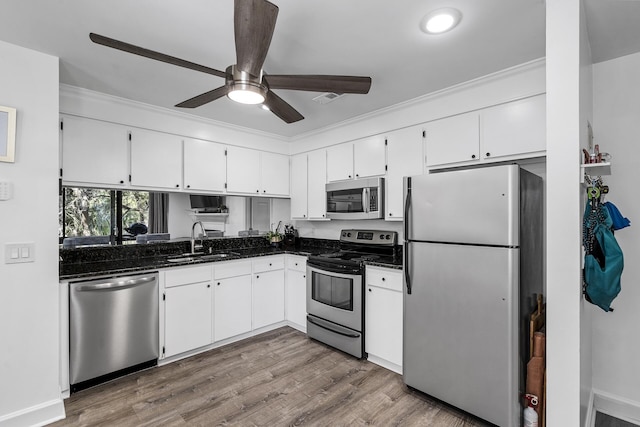 kitchen featuring sink, hardwood / wood-style flooring, ceiling fan, appliances with stainless steel finishes, and white cabinets