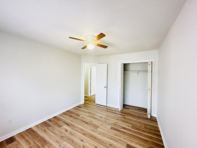 unfurnished bedroom with wood finished floors, baseboards, a closet, and a textured ceiling