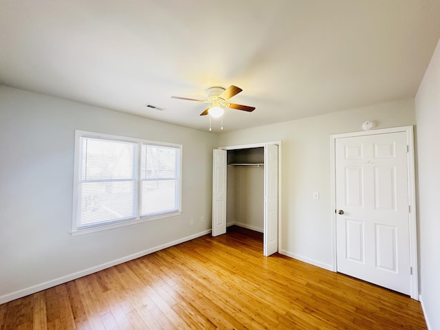 unfurnished bedroom featuring visible vents, ceiling fan, baseboards, light wood-type flooring, and a closet