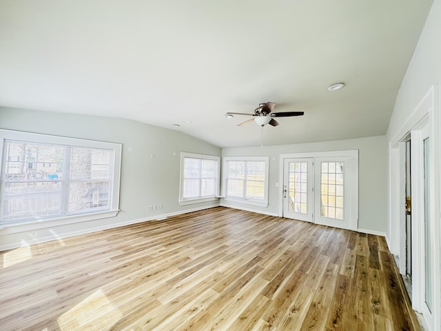 unfurnished living room with ceiling fan, baseboards, lofted ceiling, and wood finished floors