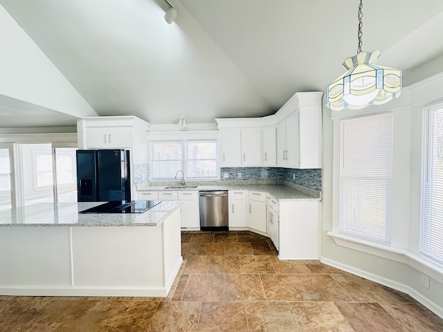 kitchen with light stone countertops, lofted ceiling, a sink, decorative backsplash, and black appliances