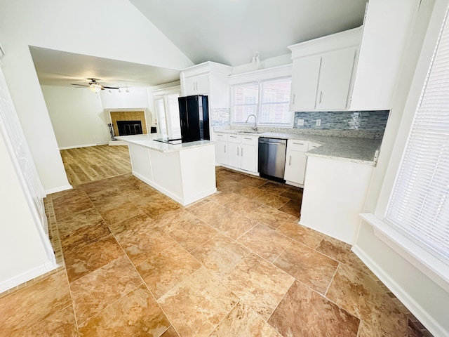 kitchen with a tiled fireplace, open floor plan, dishwasher, decorative backsplash, and freestanding refrigerator