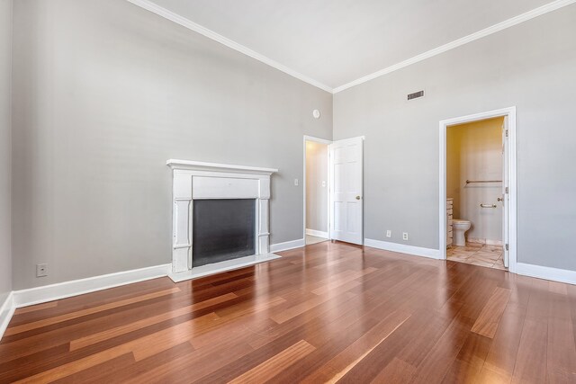 1 King Street 209 & 210, Charleston, SC 29401 - unfurnished living room featuring a towering ceiling, wood finished floors, a fireplace with flush hearth, and crown molding