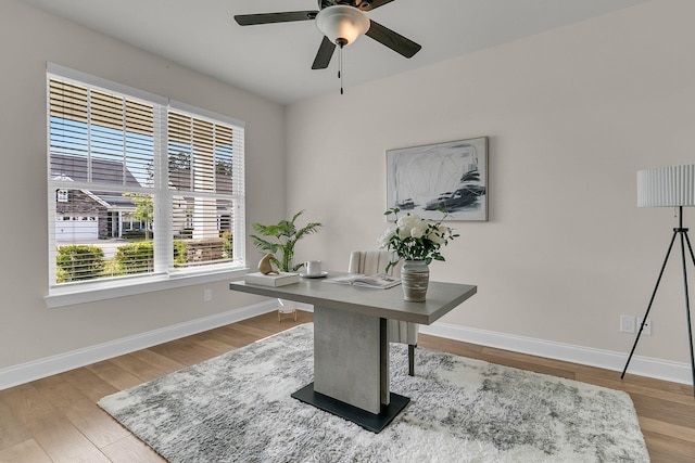 home office with a ceiling fan, baseboards, and wood finished floors