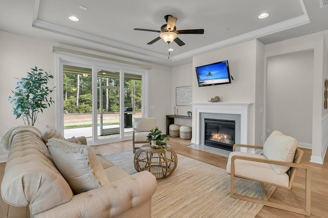 living room featuring a tray ceiling and light wood-style flooring