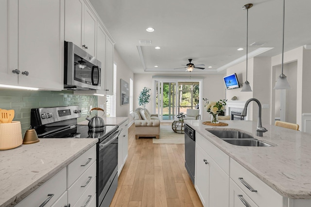 kitchen featuring visible vents, stainless steel appliances, a ceiling fan, a sink, and open floor plan
