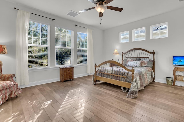 bedroom with baseboards, visible vents, hardwood / wood-style flooring, and a ceiling fan