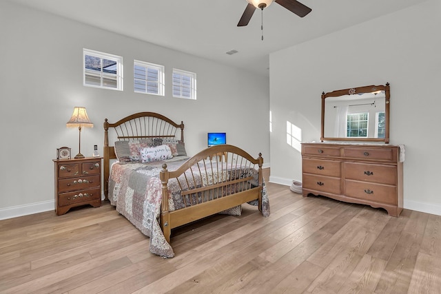 bedroom featuring baseboards, a ceiling fan, and light wood finished floors