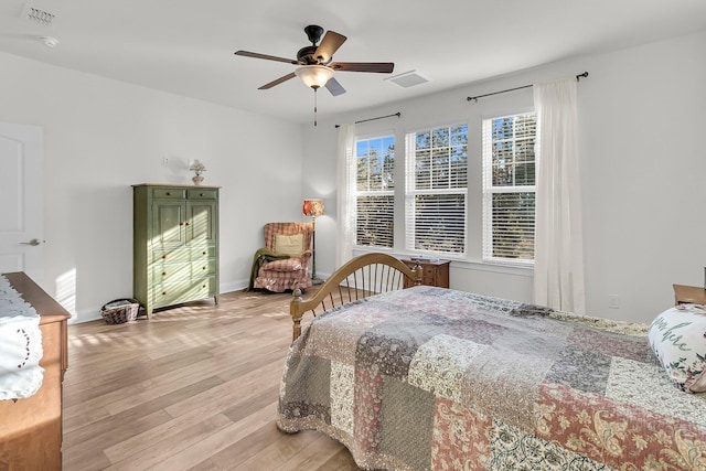 bedroom featuring ceiling fan, baseboards, light wood finished floors, and visible vents