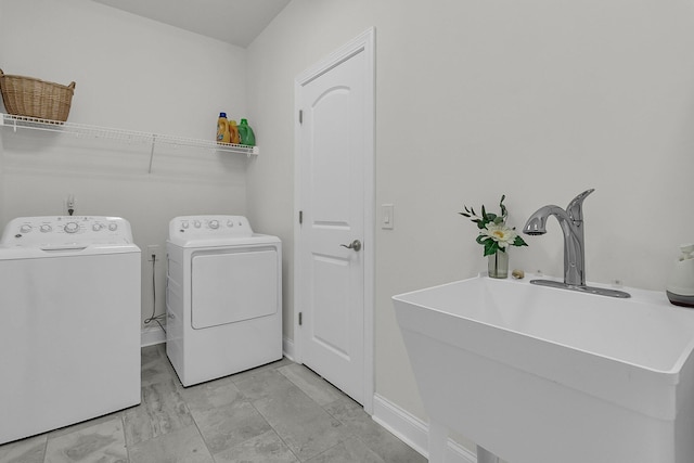 laundry area featuring baseboards, a sink, laundry area, and washer and dryer