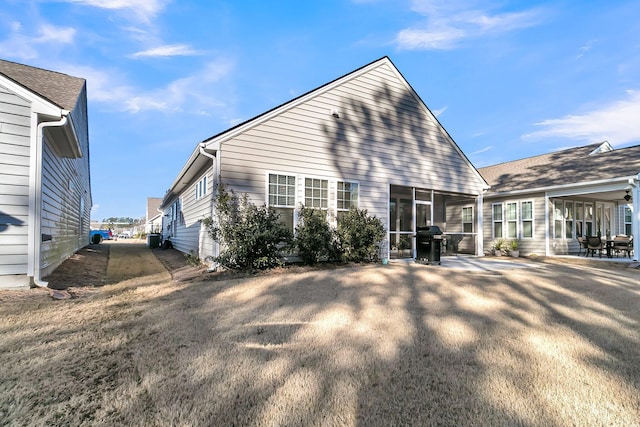 rear view of property with a sunroom and a patio area