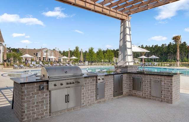 view of patio with a grill, a community pool, a sink, an outdoor kitchen, and a pergola