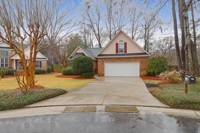 traditional-style house with a garage, brick siding, concrete driveway, and a front yard