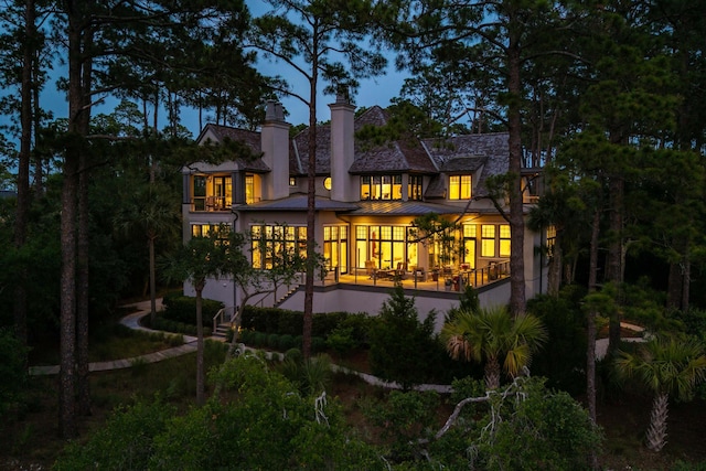 79 Trailing Vine Way, Kiawah Island, SC 29455 - rear view of house featuring a standing seam roof, a chimney, a metal roof, and stucco siding