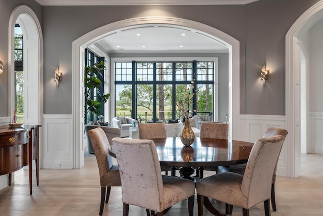 79 Trailing Vine Way, Kiawah Island, SC 29455 - dining space featuring a decorative wall, a wainscoted wall, crown molding, arched walkways, and light wood finished floors